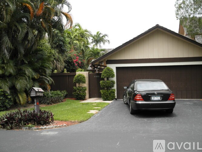 A black car is parked in front of a garage.