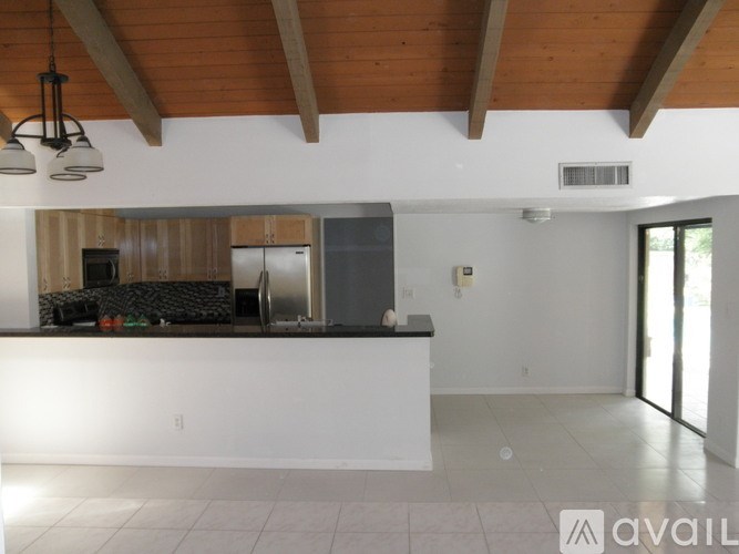 A kitchen area with a white counter and a refrigerator.