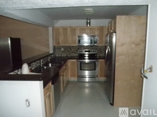 A kitchen with a stove top oven and a refrigerator.