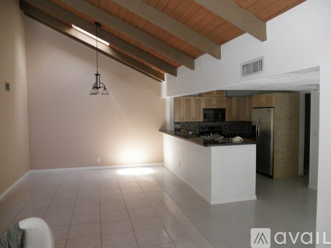 A kitchen area with a white counter and a refrigerator.
