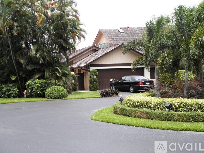 A black car is parked in front of a house.