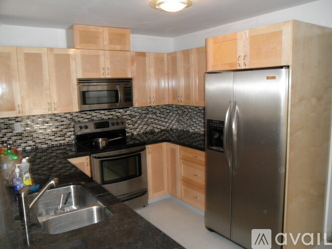 A kitchen with a sink, stove, and refrigerator.