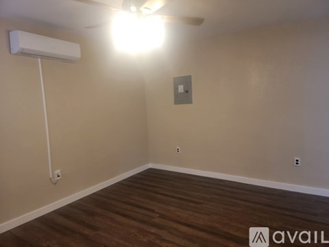 A room with a ceiling fan and a wall-mounted air conditioner unit.
