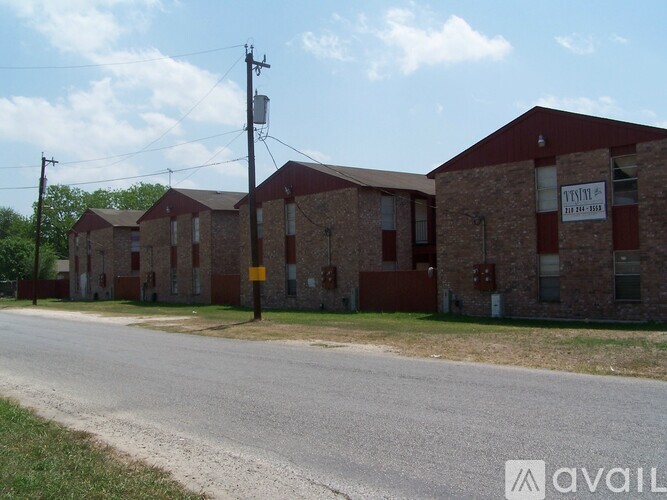 A street view of a brick building with a sign that says "AVAILABLE".