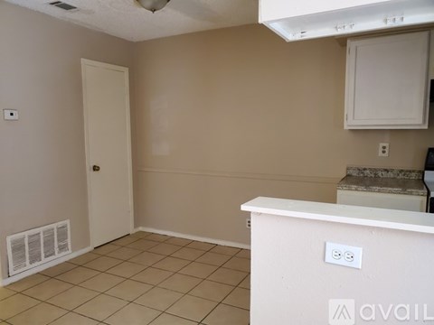 A room with a white door and a white counter.