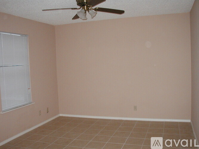 A room with a ceiling fan and tiled floor.