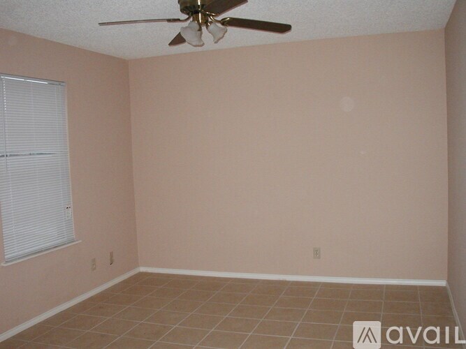 A room with a ceiling fan and tiled floor.