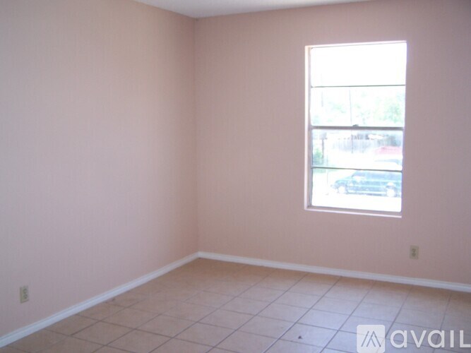 A room with a window and tiled floor.