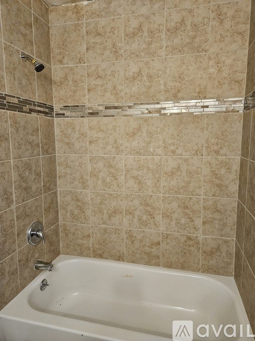 A bathroom with a tiled shower and a white bathtub.