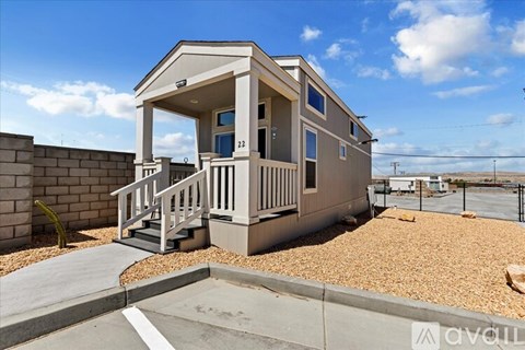 A small house with a porch and a front yard.