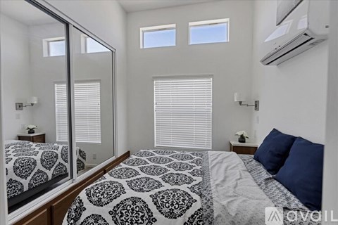 A bedroom with a large bed and a mirror on the wall.