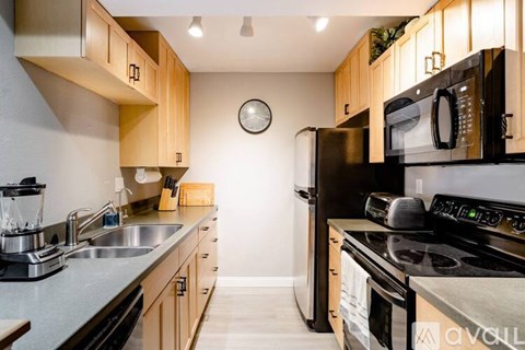 A kitchen with wooden cabinets and black appliances.