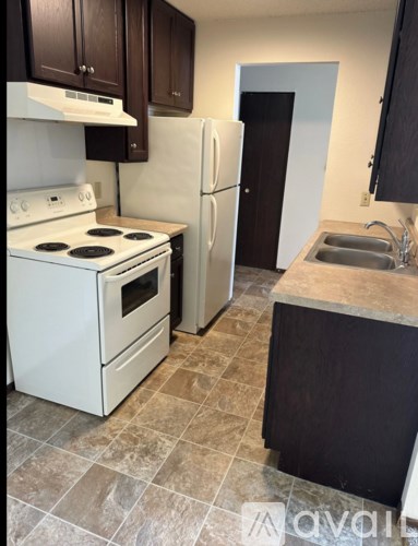 A kitchen with a white stove top oven and a white refrigerator.