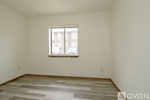 A white toilet is in a bathroom with a white tub.