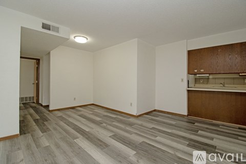 A bedroom with a brown door and a white wall.