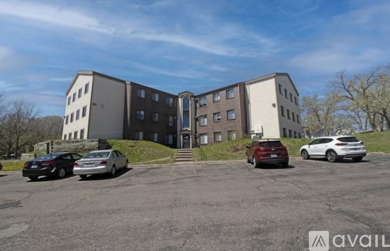 A parking lot with cars and a building in the background.