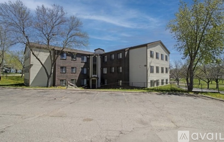A large, multi-story building with a parking lot in front.