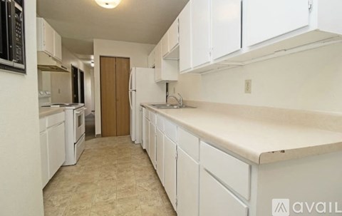 A kitchen with white cabinets and a beige countertop.