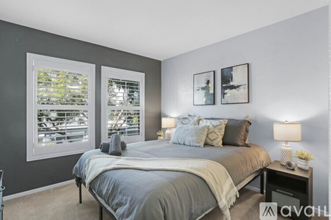 A bedroom with a large bed and two framed pictures on the wall.