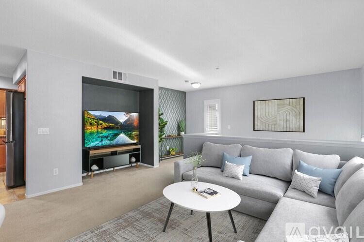 A living room with a grey couch and a television.