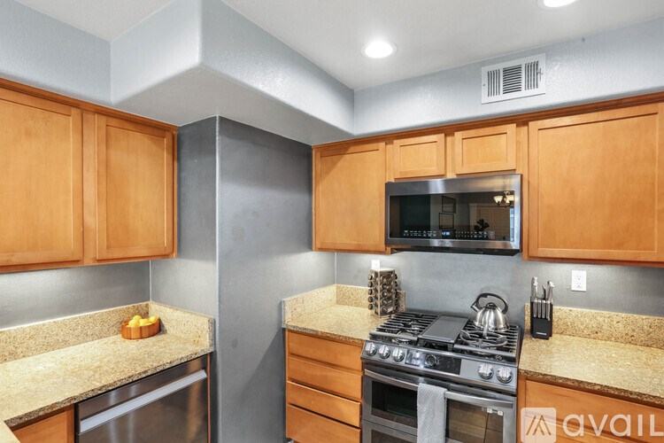 A kitchen with wooden cabinets and a stainless steel oven.