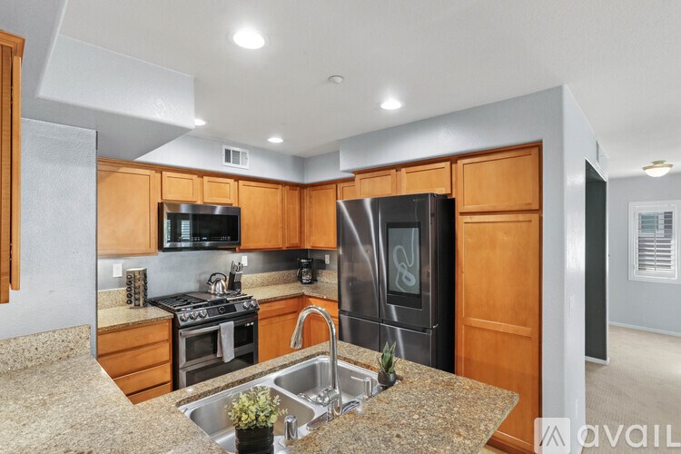 A kitchen with granite countertops and wooden cabinets.