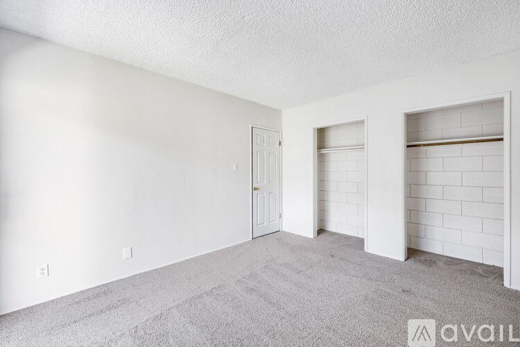 A sparsely furnished room with a white door and a white wall.