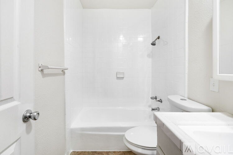A white bathroom with a toilet, sink, and bathtub.
