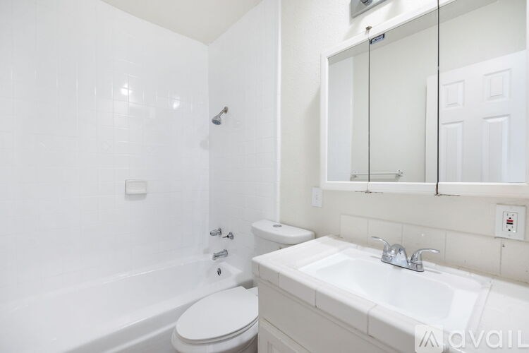 A white bathroom with a toilet, sink, and bathtub.