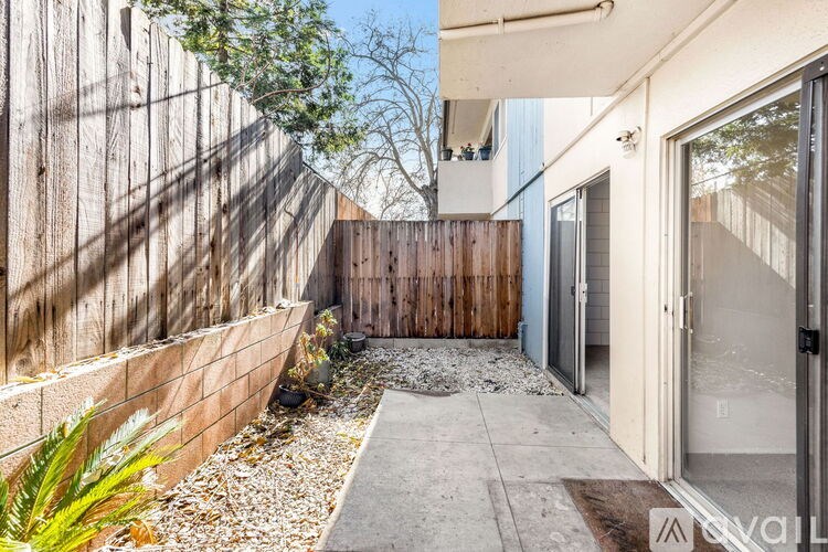 A narrow alley with a wooden fence and a gravel path.