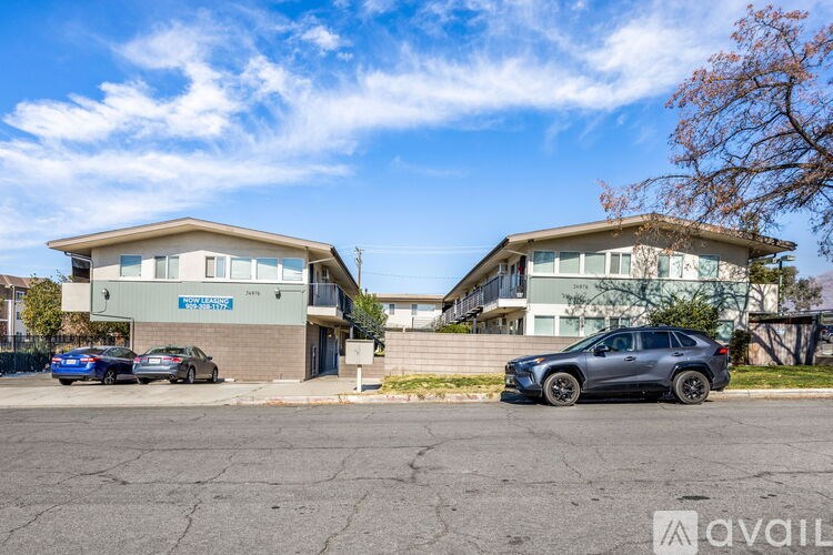 Two houses with cars parked in front of them.
