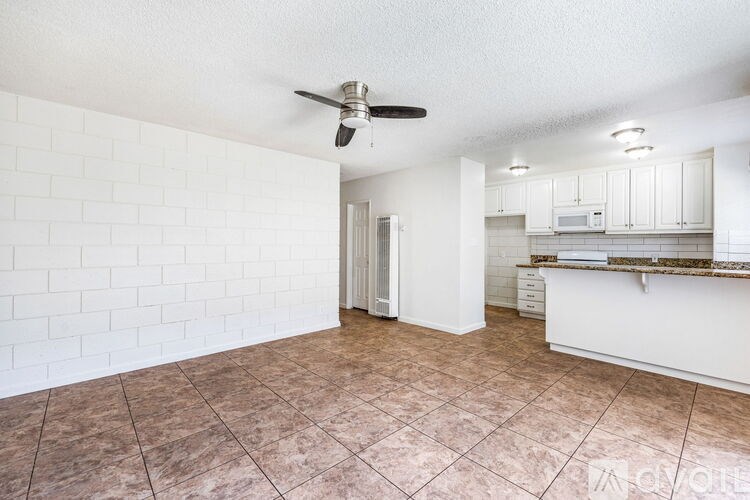 A room with a fan and tiled flooring.