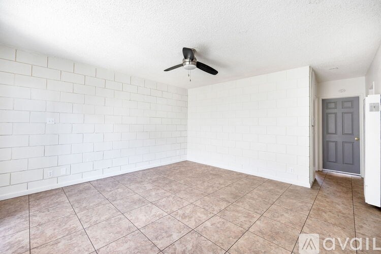 A room with a ceiling fan and a door.