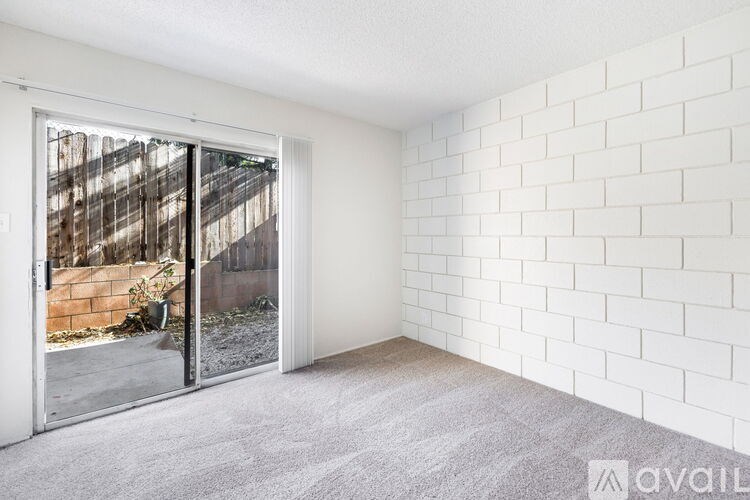 A room with a white brick wall and a carpeted floor.