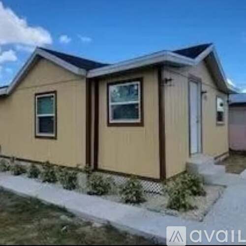 A small house with a brown door and windows.