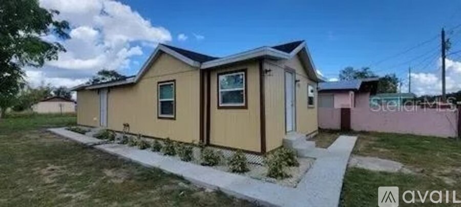 A beige house with a brown door and windows is for sale.