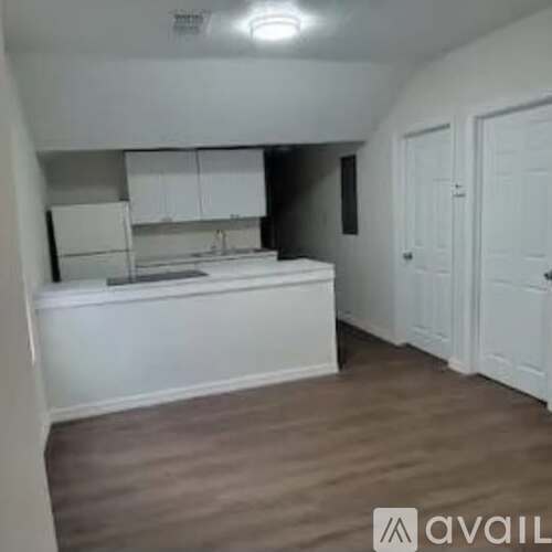 A kitchen with white cabinets and a white countertop.