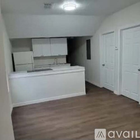 A kitchen with white cabinets and a white countertop.