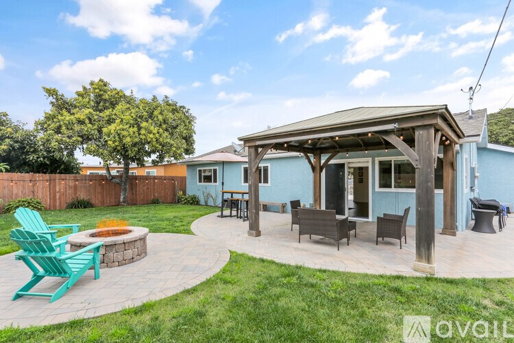 A blue house with a covered patio and outdoor furniture.