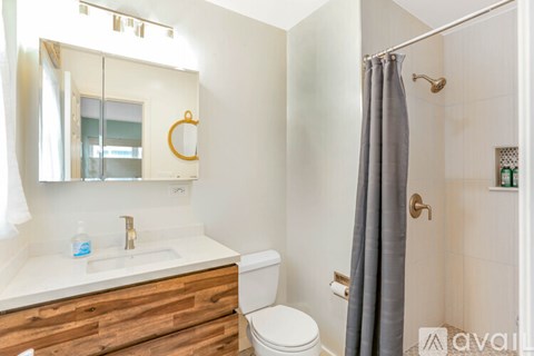 A bathroom with a toilet, sink, and shower.