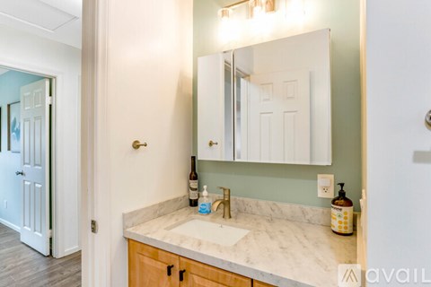 A bathroom with a marble countertop and a large mirror above the sink.