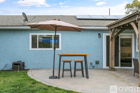 A patio with a table and chairs under an umbrella.