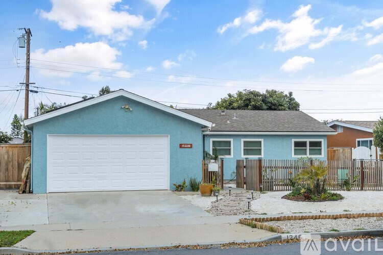 A blue house with a white garage door is for sale.