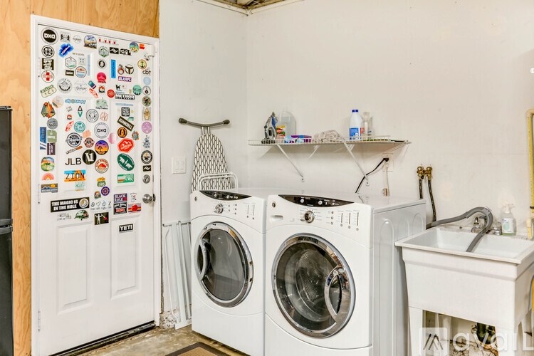 A small laundry room with a washer and dryer and a sink.