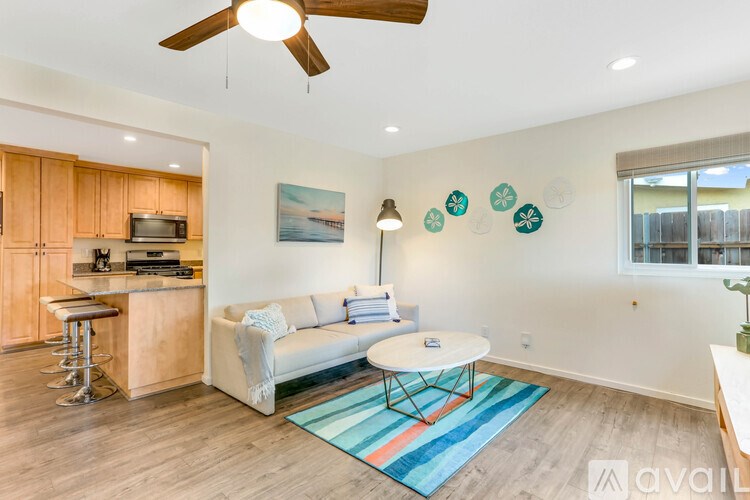 A living room with a white couch and a wooden cabinet.