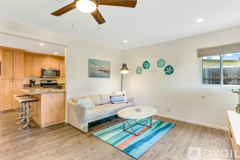 A living room with a white couch and a wooden cabinet.