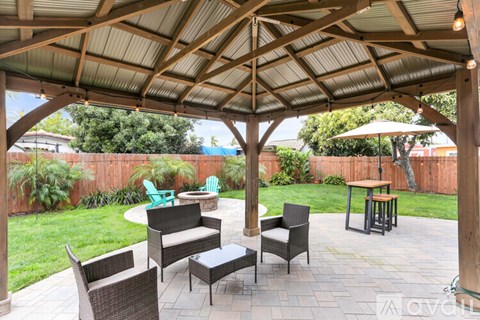 A patio with a table and chairs under a roof.