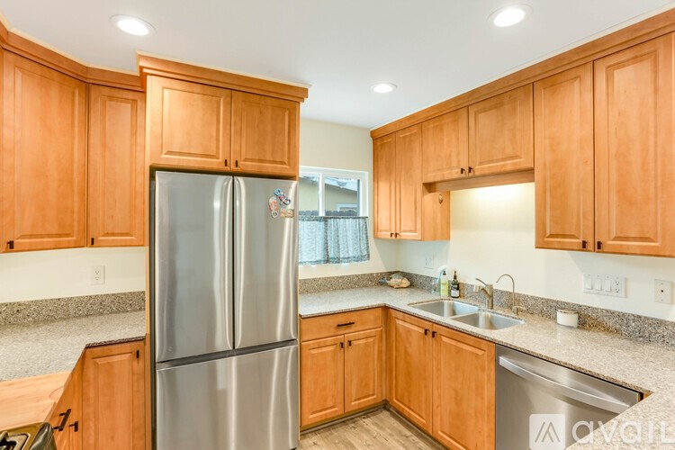 A kitchen with wooden cabinets and a stainless steel refrigerator.