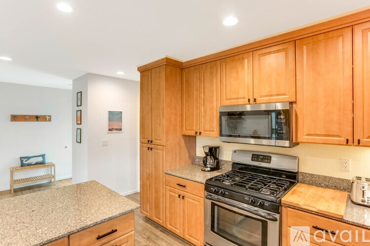 A kitchen with wooden cabinets and granite countertops.