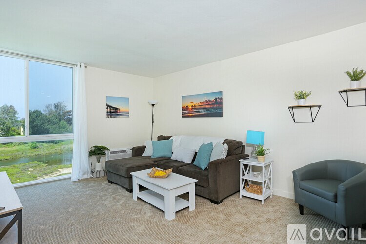 A living room with a couch, chair, and a table with a bowl of fruit on it.
